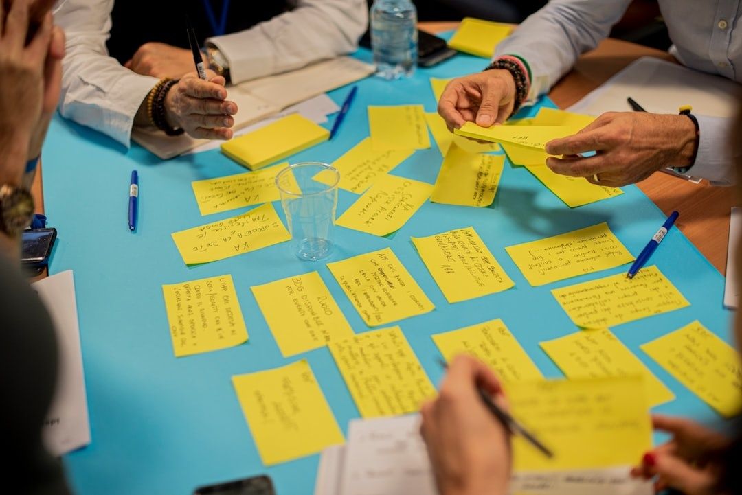 Workshopteam ordnet gelbe Notizzettel auf einem Tisch