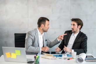 Zwei Geschäftsleute diskutieren angespannt an einem Schreibtisch
