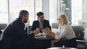 Drei Geschäftsleute diskutieren konzentriert an einem Tisch