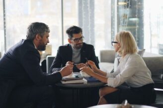 Drei Geschäftsleute diskutieren konzentriert an einem Tisch